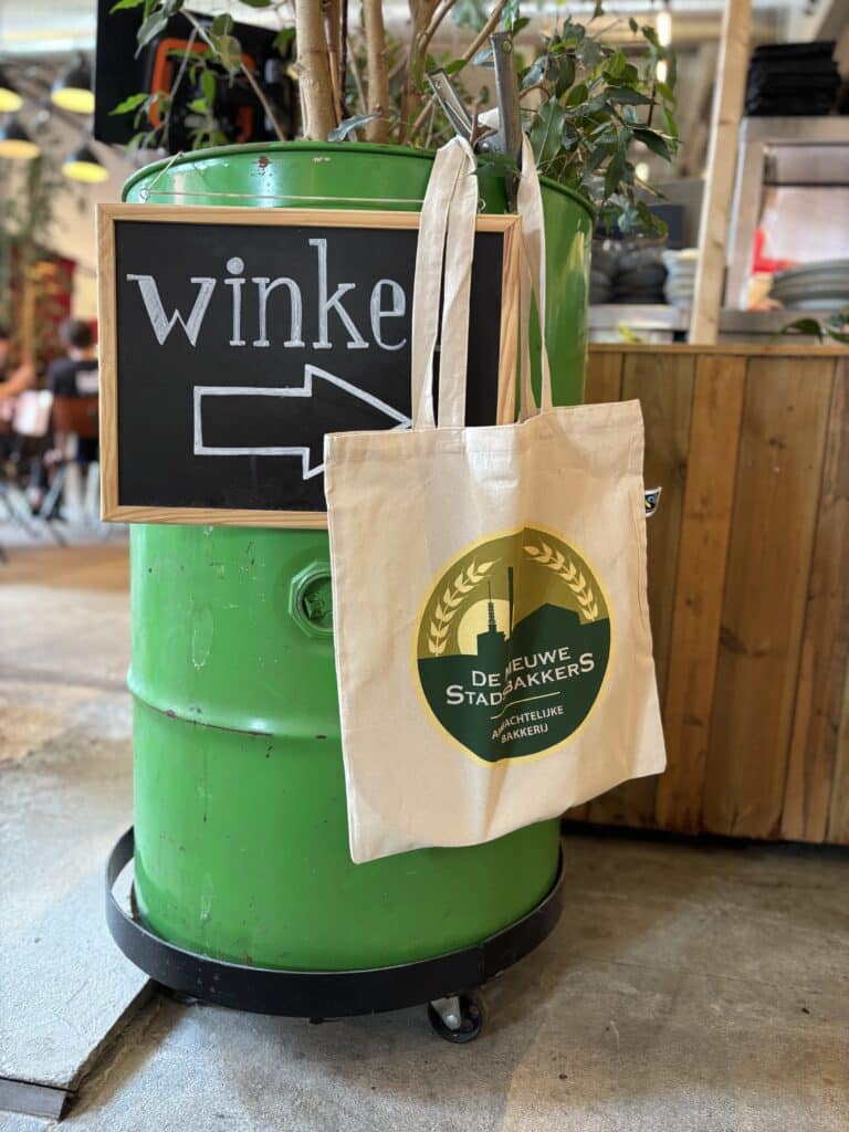 De Nieuwe Stadsbakkers tas hangend aan groene ton