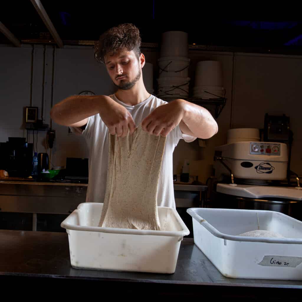 Medewerker Frederik vouwt het deeg voor het zuurdesem brood